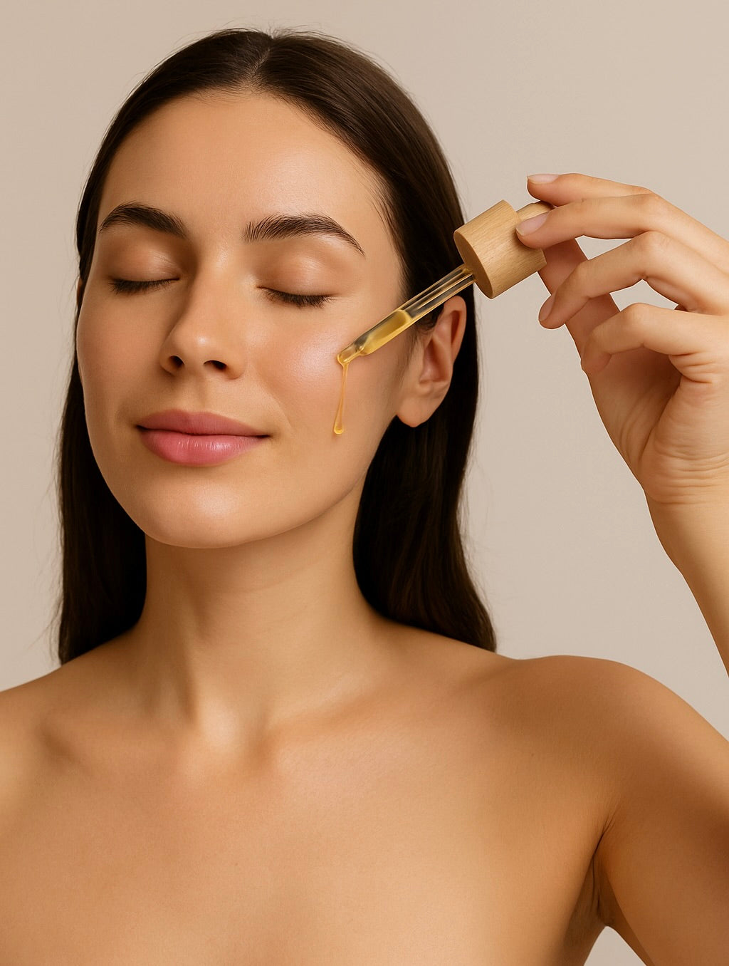 Woman applying facial oil with dropper to cheek, eyes closed, with clean and glowing skin