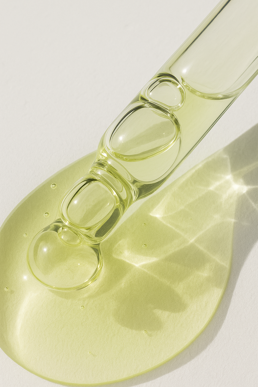 Close-up of a glass dropper with yellow liquid on a white background