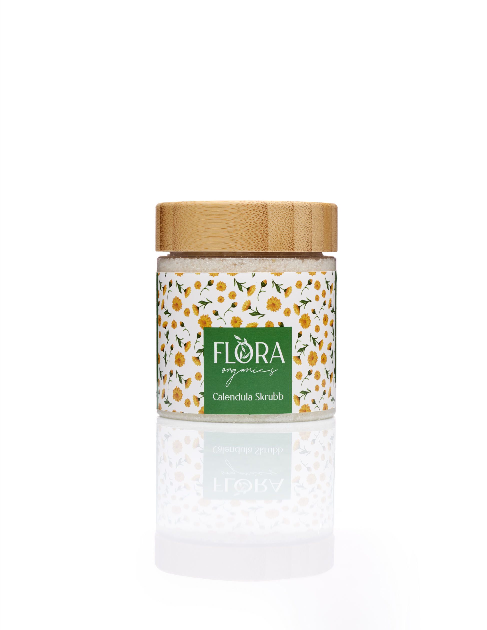 Flora Organics Calendula Scrub in glass jar with bamboo lid, reflected on white background