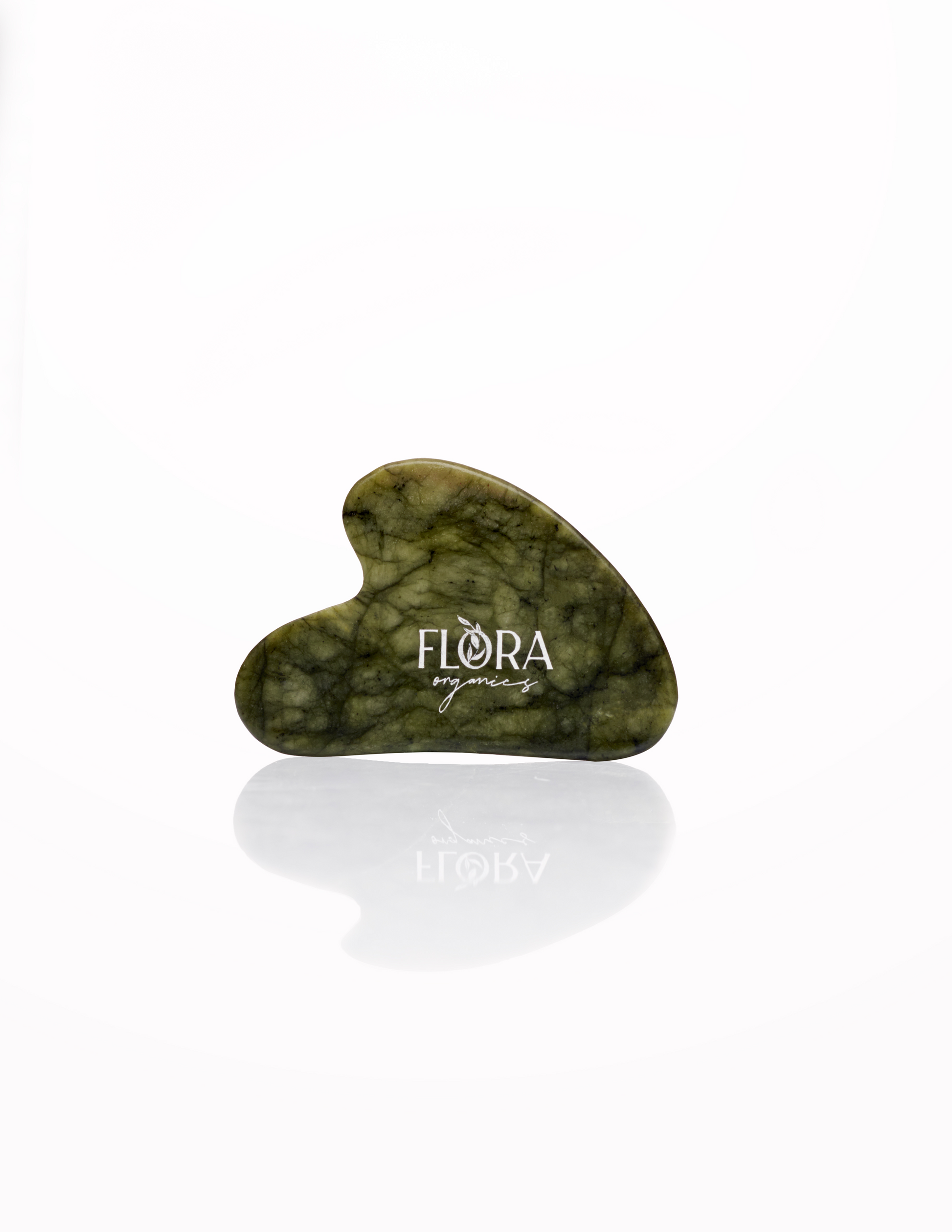Flora Organics jade gua sha stone, reflected on white background