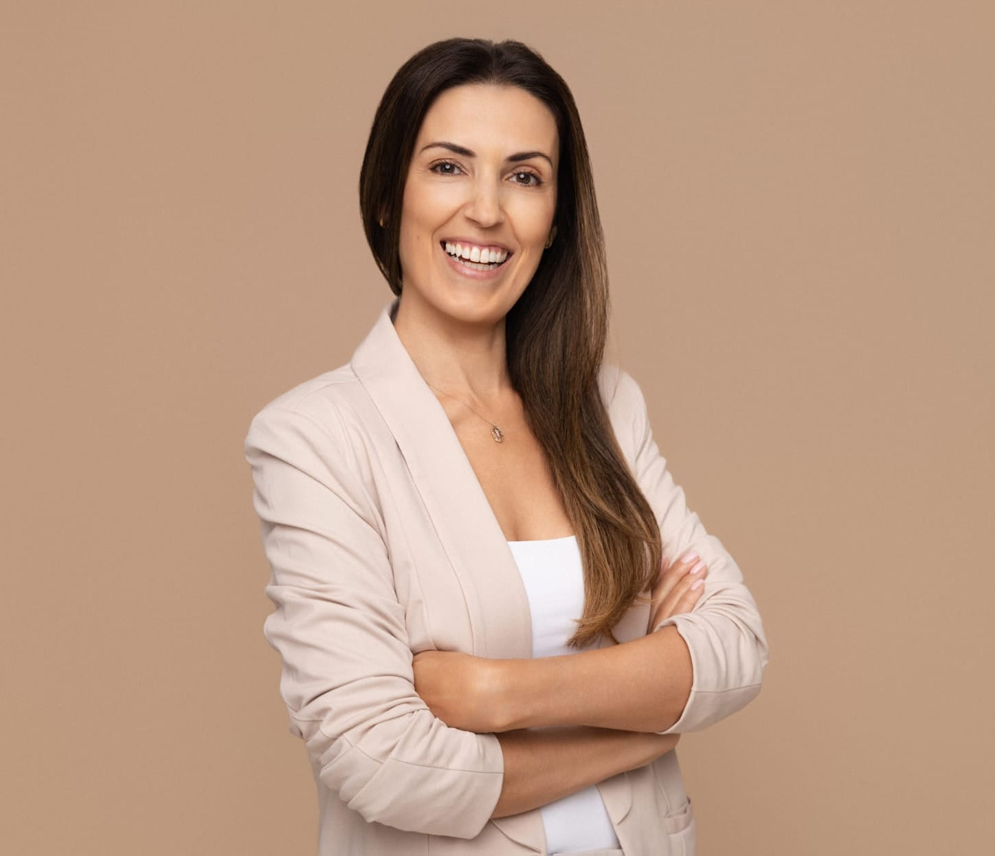 Woman with arms crossed on a beige background